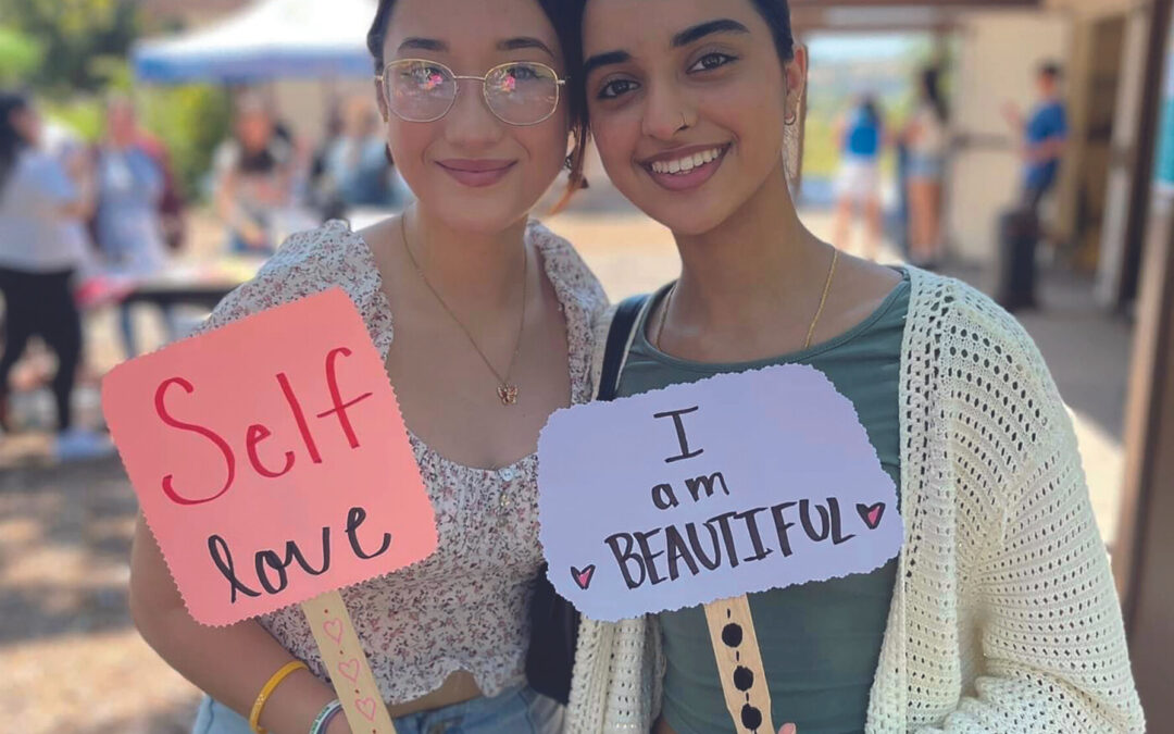 two girls holding signs