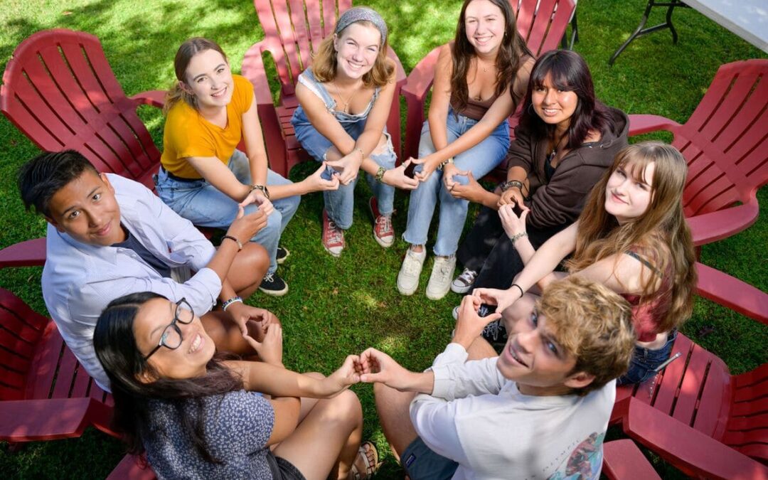 people sitting around in a circle connecting hands